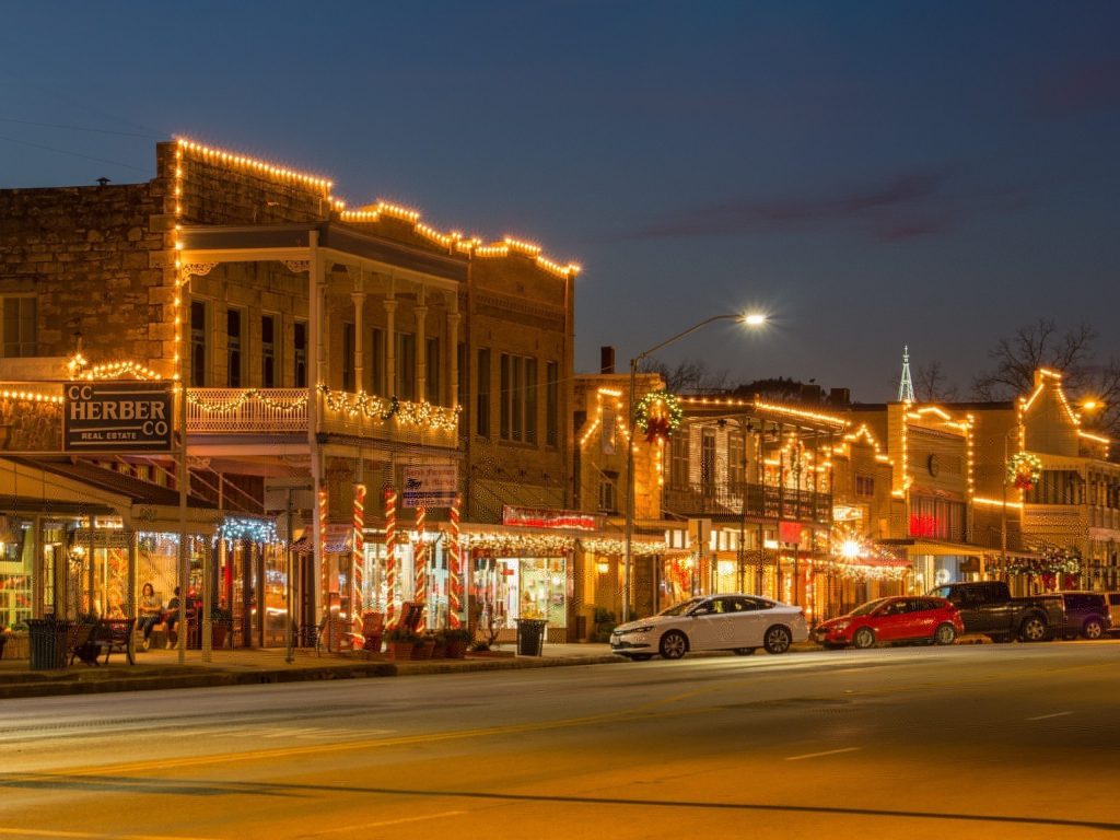 main street of fredericksburg texas at christmas with christmas lights, austin wedding venue, austin bride, dripping springs wedding, texas hill country, cheap wedding venue, budget friendly, affordable, fun things to do around austin